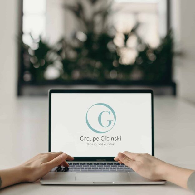 Ordinateur affichant le logo du groupe Olbinski